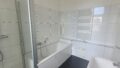 Badezimmer mit Badewanne und Dusche